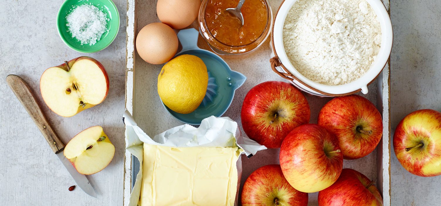 Zutaten für Apfelkuchen auf weißem Tisch