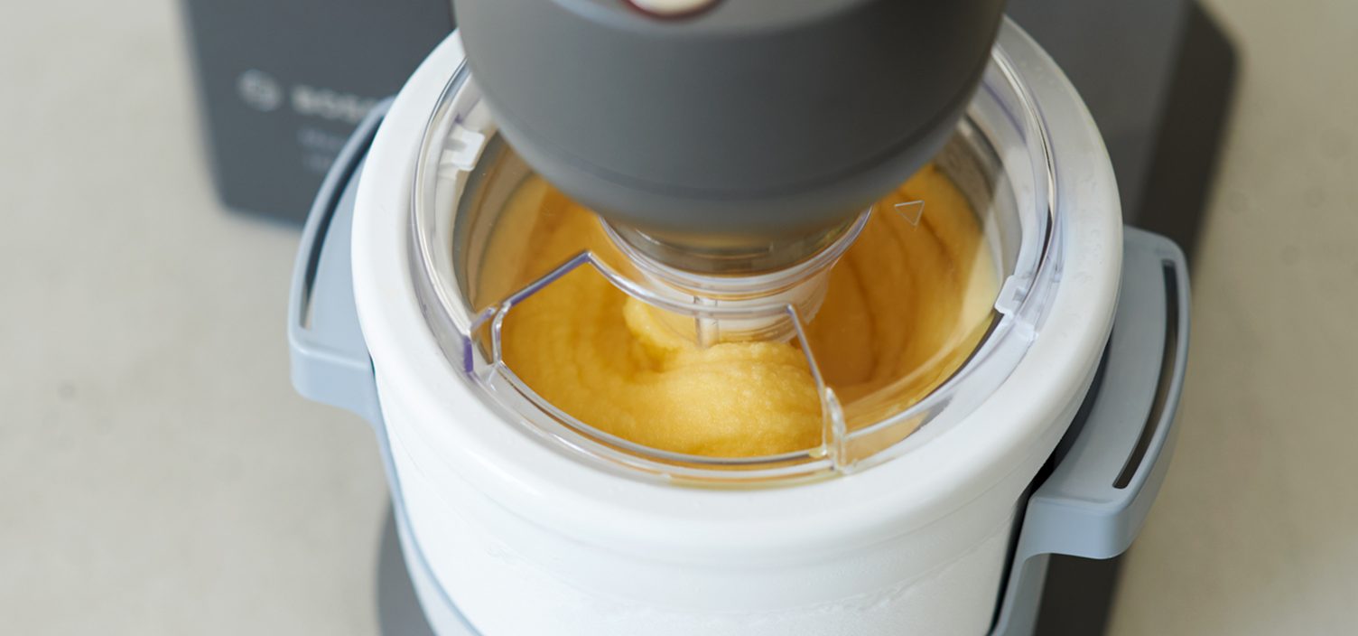 Nahaufnahme von Orangensorbet in Eisbereiter.